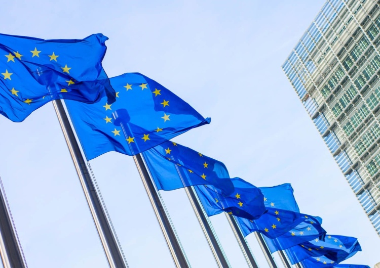 Flagi UE na tle siedziby Komisji Europejskiej Bruksela szantażuje Warszawę. Albo Polska się podda, albo nie dostanie ani grosza