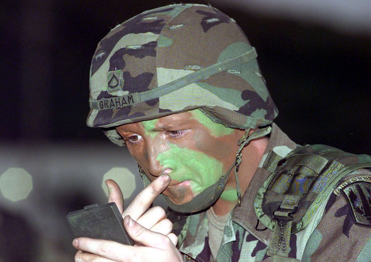 Żołnierz nakładający kamuflaż na twarz [Tylko u nas] Marcin Bąk: Plamy i taśmy – rzecz o maskowaniu